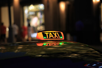 taxi lantern on the roof of the car at night - obrazy, fototapety, plakaty
