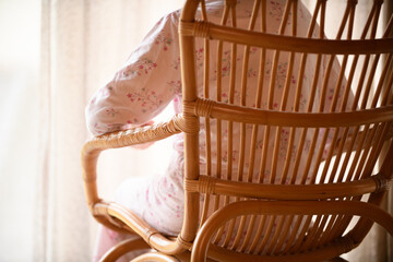 Fototapeta na wymiar パジャマ姿で籐椅子に座るシニアの女性
