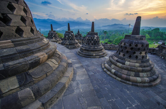 Ancient Buddhist temple during sunset evening time against orange cloudy sky