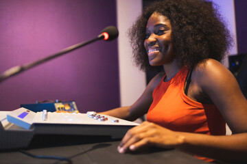 Happy black woman recording sound