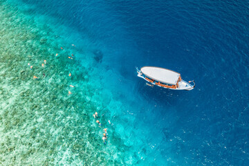 Aerial view sailing boat next to reef. Bird eye view, water sport theme. Snorkel excursion,...