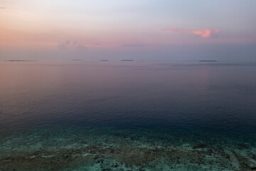 Minimalist aerial seascape - sunset over calm water. Aerial panoramic view of sunset over ocean. Skyline, clouds and water. Beautiful serene scene minimalistic seascape