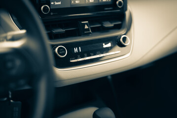 Toned photo highest temperate heat setting with knobs, digital display inside modern leather car...