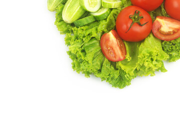 Fresh cucumbers and tomatoes on salad leaves background isolated on white.