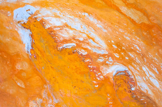 Textured surface with yellow background and uneven blue mineral formations