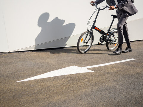 Unrecognizable person riding bicycle on pavement