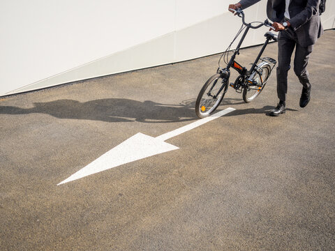 Unrecognizable person riding bicycle on pavement