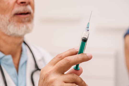 Unrecognizable doctor with syringe in hospital