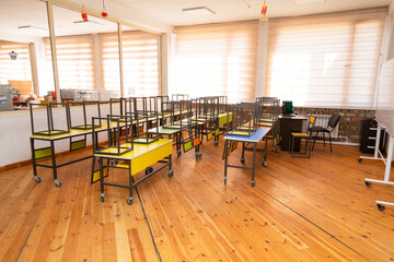 Empty school classroom with benches and tables