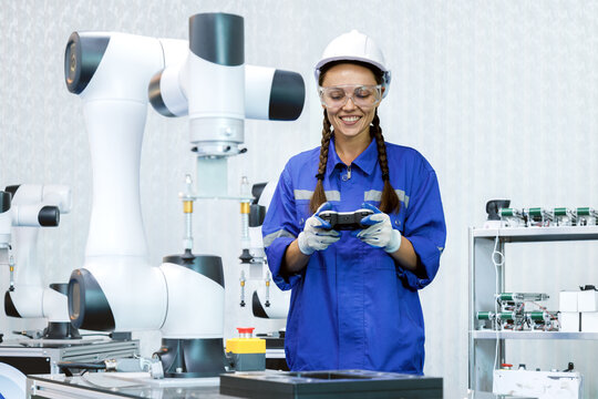 female automation machine engineer student study and inspection control robot arm machine in university or factory workshop. ai robot technology new innovation trend of manufacturing in industry 5.0