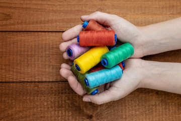 Cotons of thread in hand. Multi-colored threads for sewing