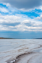Rain cumulus clouds over the dry and self-sedimentary table salt covered muddy bottom
