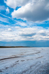 Rain cumulus clouds over the dry and self-sedimentary table salt covered muddy bottom