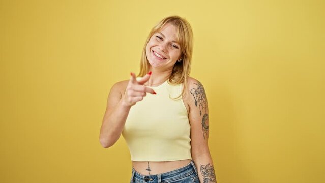 Young blonde woman smiling confident doing telephone gesture with hand over isolated yellow background