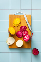 Sliced beets of different colors on a cutting board, white, yellow, purple.