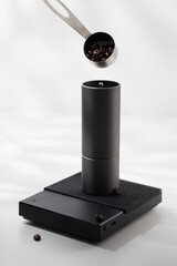 Putting coffee beans into a manual coffee grinder.