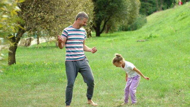 Father and daughter do yoga, yoga fails. father and child playfully engage in outdoor sports. family learns meditation practices