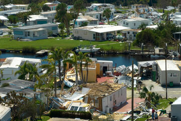 Hurricane strong wind destroyed suburban house roofs in Florida mobile home residential area....
