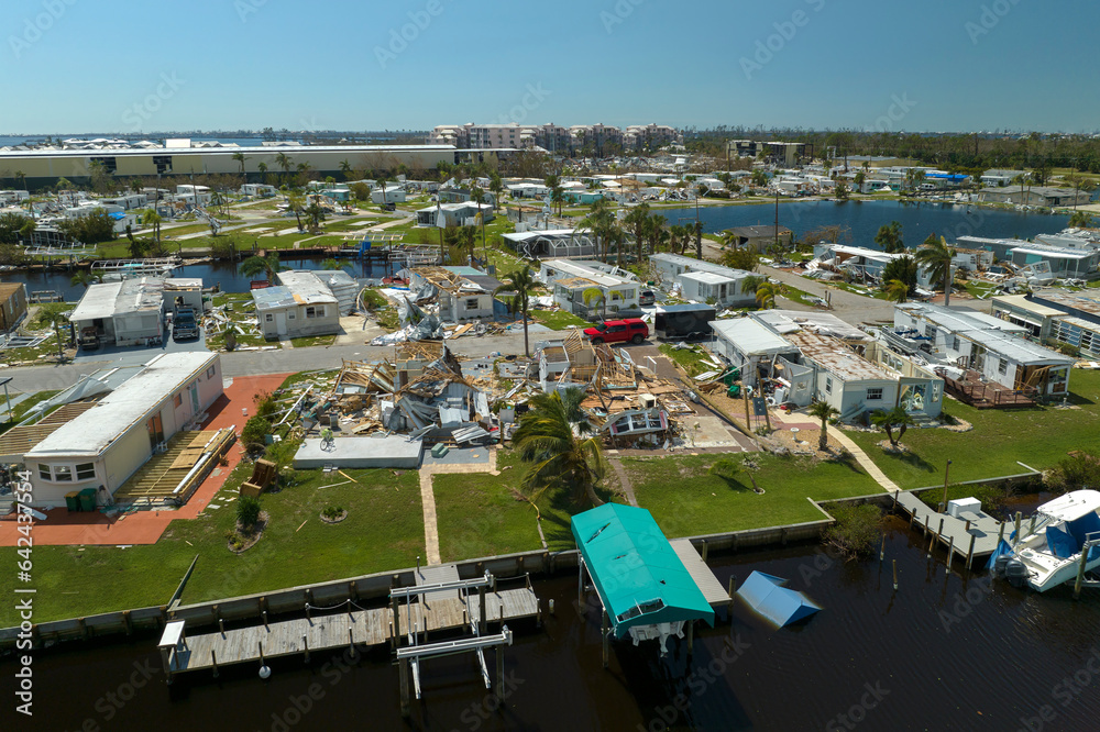 Wall mural Severely damaged houses after hurricane in Florida mobile home residential area. Consequences of natural disaster