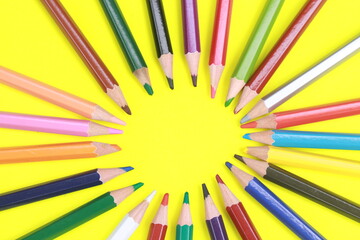 Wooden colored pencil with circular pattern isolated on yellow background.