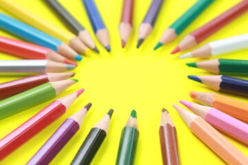 Wooden colored pencil with circular pattern isolated on yellow background.