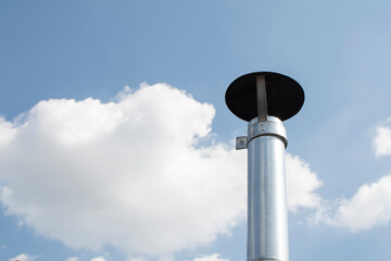 View of a part of a ventilation pipe against blue sky