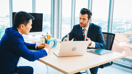 Two business people talk project strategy at office meeting room. Businessman discuss project...