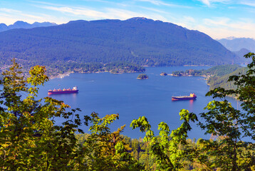 Shipping on beautiful Burrard Inlet, BC, as seen from a Burnaby Mountain Park viewpoint in summer.