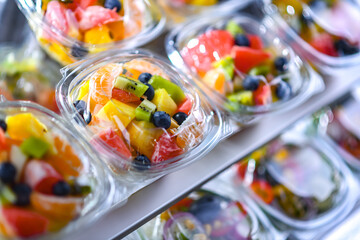 Boxes with pre-packaged fruit salads in a commercial fridge