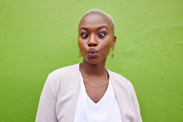 Happy, silly and young black woman by a green wall with trendy, classy and elegant jewelry and outfit. Happiness, goofy and African female model with positive and confident attitude with fashion. - obrazy, fototapety, plakaty