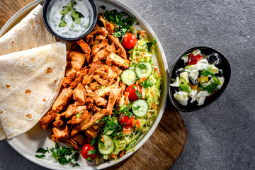 Kebab served with pita bread, vegetable salad and tzatziki