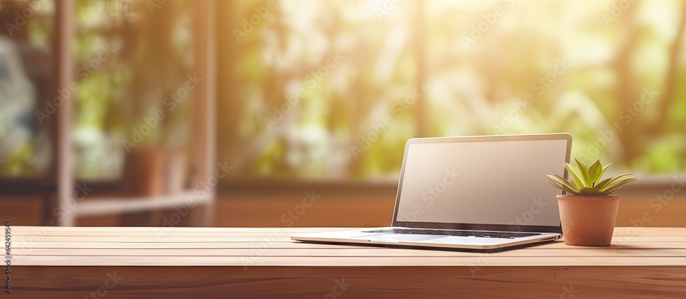 Poster blurred office background with a wooden desk laptop wireless mouse graphics tablet and notebook