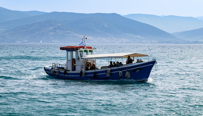Nafplio, Greece - 05 14 2023: People on a sea cruise in a finishing boat in the harbor of Nafplio...