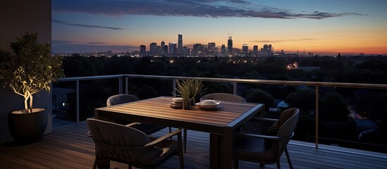 Dusk interior photograph of a contemporary city apartment balcony with outdoor furniture and distant trees