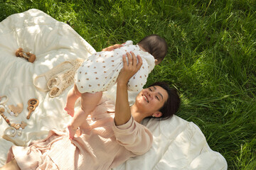 Importance of Outdoor Play. mom and her infant playing airplane on a lawn, this photo exemplifies the vital role that outdoor activities have in a child s early development and bonding.