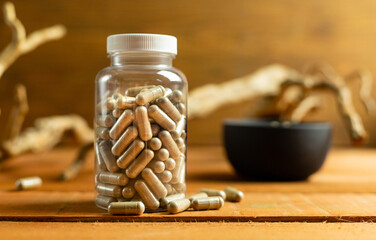 Jar with herbal capsules, medicine to help replenish vitamins and minerals, natural surroundings,...