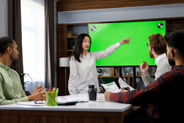 Marketing strategy analysis, stock market trading or corporate teamwork. A team of startups at a table with a large green screen TV. Mixed race business team.