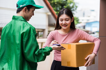 Smiling Asian woman sign autograph to pick up parcel box - obrazy, fototapety, plakaty