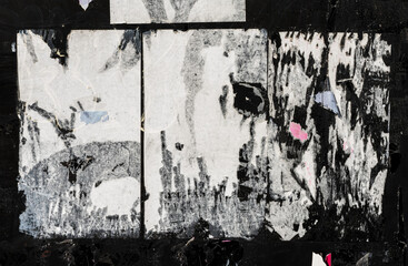 White Torn Ripped Aged Paper Poster on the Black Wall Surface. Grunge Rough Dirty Rust Background....