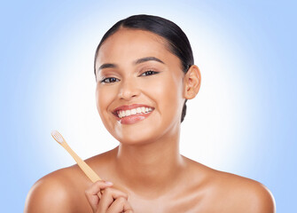 Portrait, woman and brushing teeth in studio for dental care, beauty or healthy smile on blue...