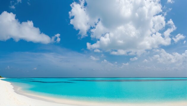 Sandy beach with white sand and rolling calm wave of turquoise ocean on sunny day, white clouds in blue sky background