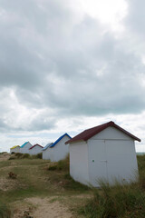 Fototapeta na wymiar Beach cabins and seashore in Gouville sur Mer, Manche, Normandy, France in various lights