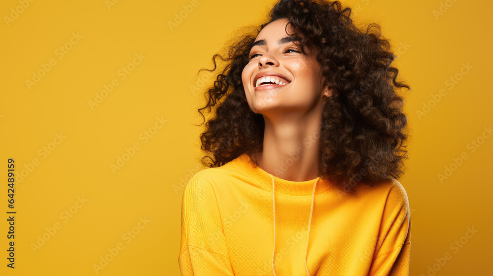 Canvas Prints Young woman laughs against a yellow background.