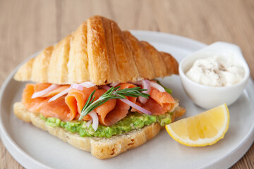 Croissant with smoked salmon, avocado and lemon