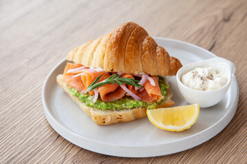Croissant with smoked salmon, avocado and lemon