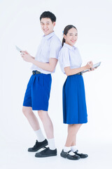 Back to school. Thai students. The boy and girl standing and using digital tablet.