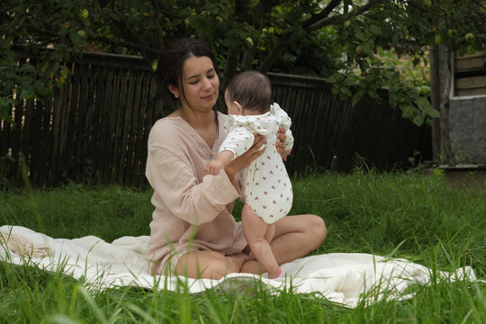 jubilant mom cuddles her infant, absorbing the serenity of their garden setting, exemplifying self-care in motherhood. Self-Care Strategies for New Moms