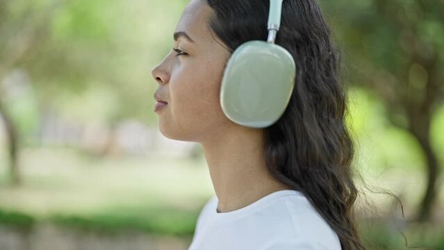 African American Woman Listening To Music Walking At Park