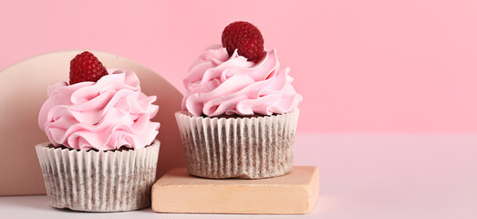 Tasty raspberry cupcakes on pink background with space for text