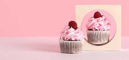 Decorative stand and tasty raspberry cupcakes on pink background with space for text